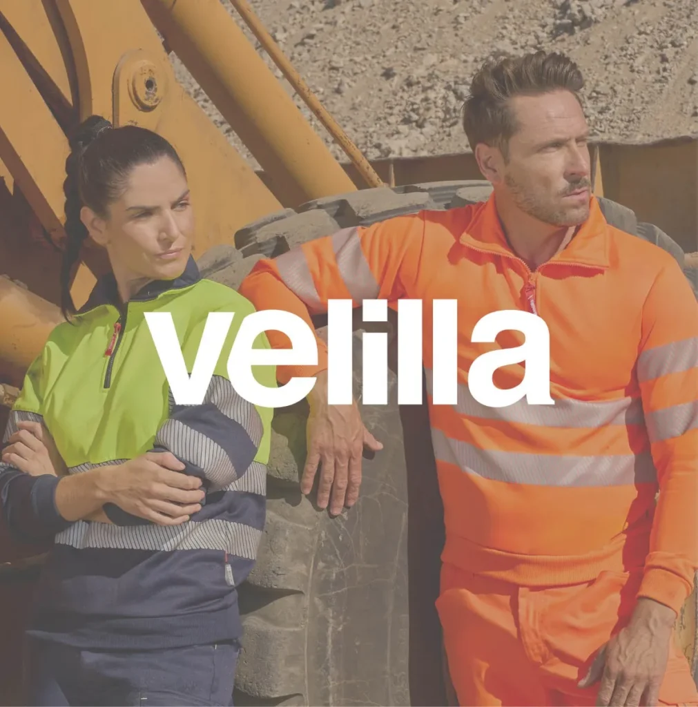 Dos trabajadores con vestuario laboral de Velilla y el logo oficial, distribuidor en Vigo.